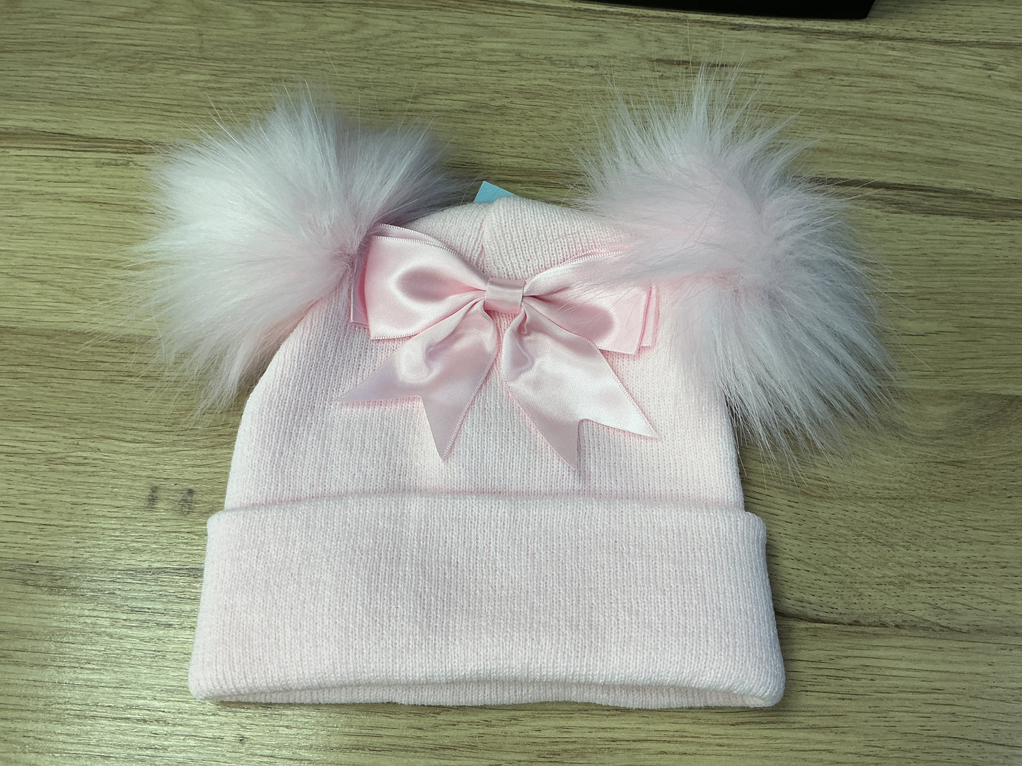 Pink ribbed hat with pink faux pom Poms ,large bow and turnover